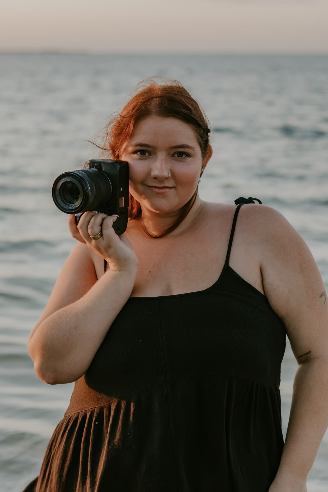 Madison holding her camera by the water