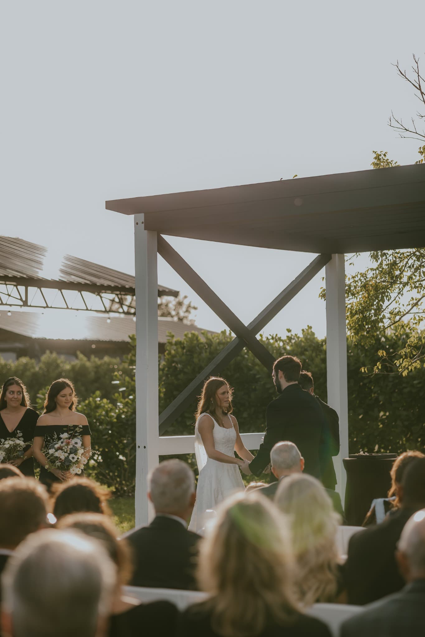 Bride and groom exchanging vows during an outdoor sunset wedding ceremony